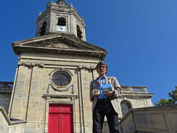 L'historien caennais Vincent Juhel pose devant l'église Saint-Michel de Vaucelles.