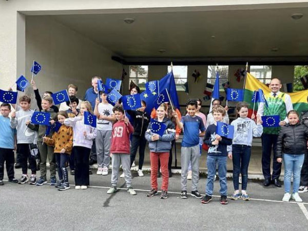 Groupe d'enfants dans une école avec drapeaux européens