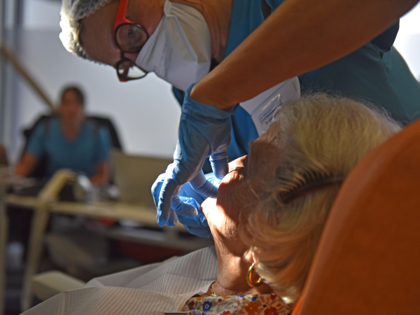 Un dentiste apporte des soins auprès d'une patiente en Ehpad.