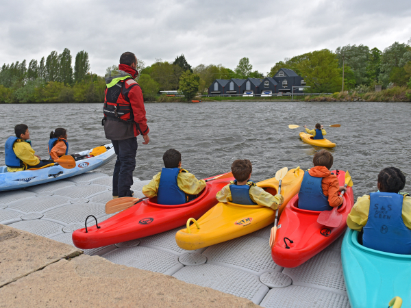 Enfants en route pour faire du kayak accompagné d'un animateur de la Ville 