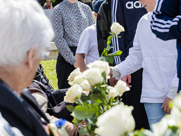 Photographie d'archives d'une cérémonie de la transmission, distribution de roses blanches par des enfants