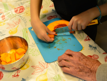 Enfants et seniors en atelier cuisine : zoom mains 