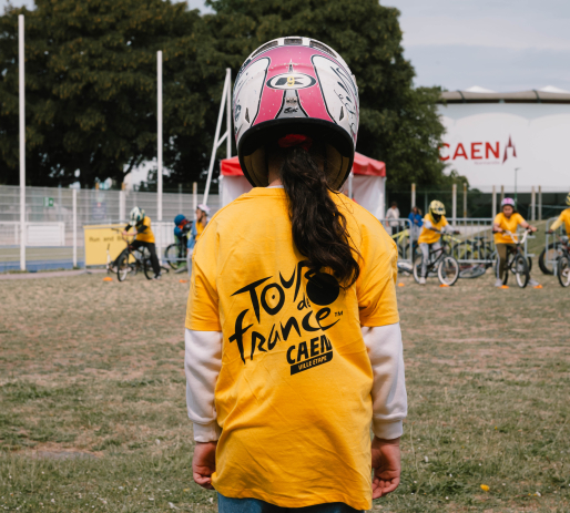 Petite fille avec un casque portant le t-shirt du Tour de France